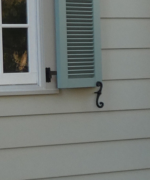 Face mounted Bahama Shutter installed on white trim. 